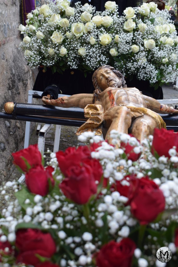 Jésus sur la croix entouré de fausses fleurs