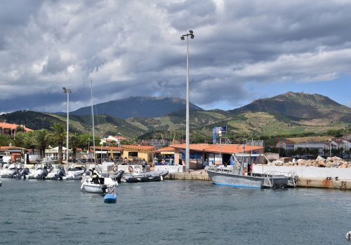Dans le port de Banyuls-sur-Mer : vue sur les reliefs et les bateaux à partir d'un catamaran.