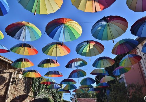Parapluies multicolores suspendus dans une rue de Sainte-Marie-la-Mer en décoration.
