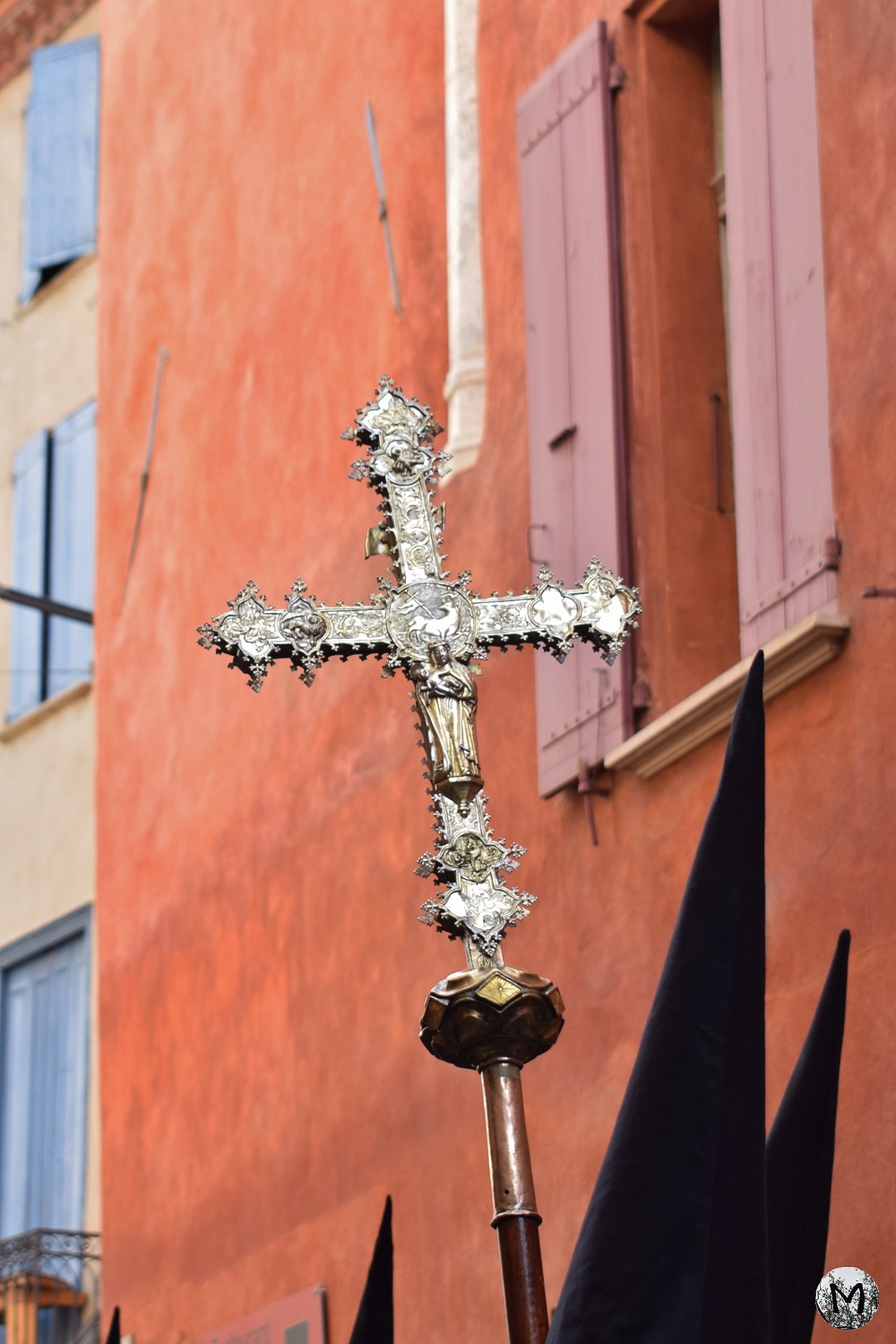 Croix religieuse devant une façade orange