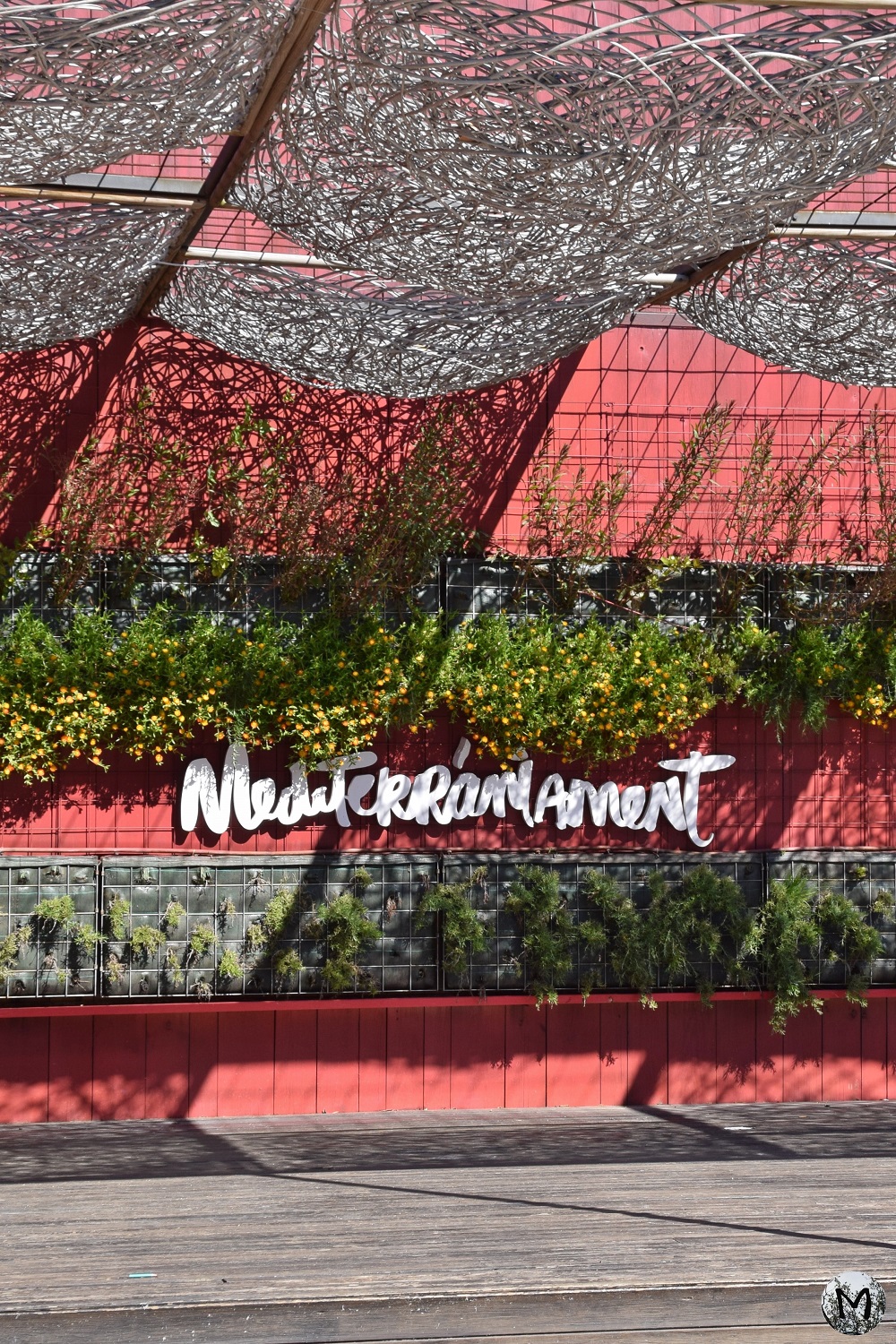Façade rouge végétale à Barcelone qui décore une terrasse gourmande du Mont-Juïc.