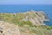 Panorama des falaises du Cap Béar avec ses monuments en ruines et ses bateaux en mer.