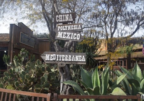 Panneaux en bois indiquant les différents univers de PortAventura dans le Far West.